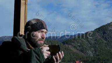 寂寞的胡须男站在观察甲板上看着一座山，喝着大杯子里的咖啡或茶。 <strong>慢慢慢慢</strong>